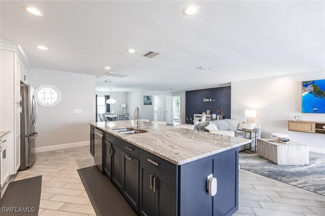 kitchen with open floor plan, appliances with stainless steel finishes, a sink, and visible vents