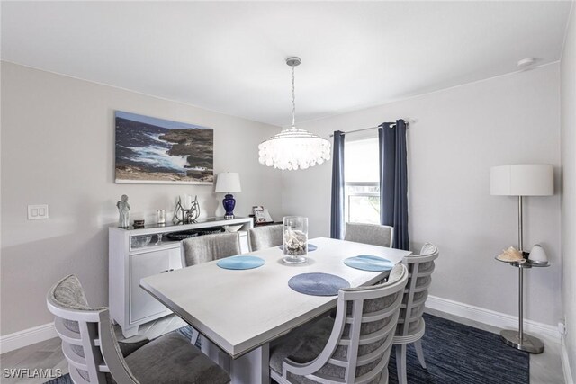 dining space with an inviting chandelier and baseboards