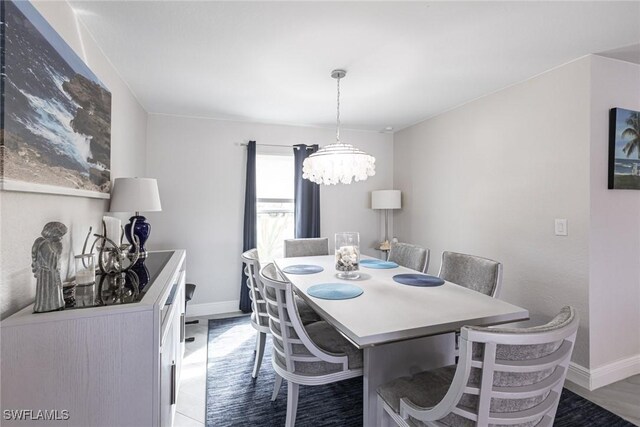 dining space featuring an inviting chandelier and baseboards