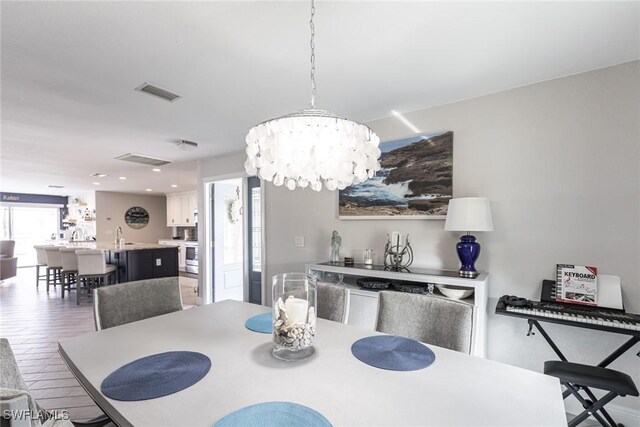 dining room with a chandelier and visible vents