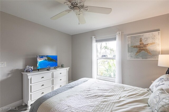 bedroom with ceiling fan and baseboards