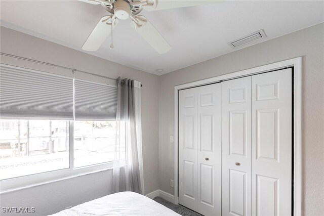 bedroom featuring baseboards, ceiling fan, visible vents, and a closet