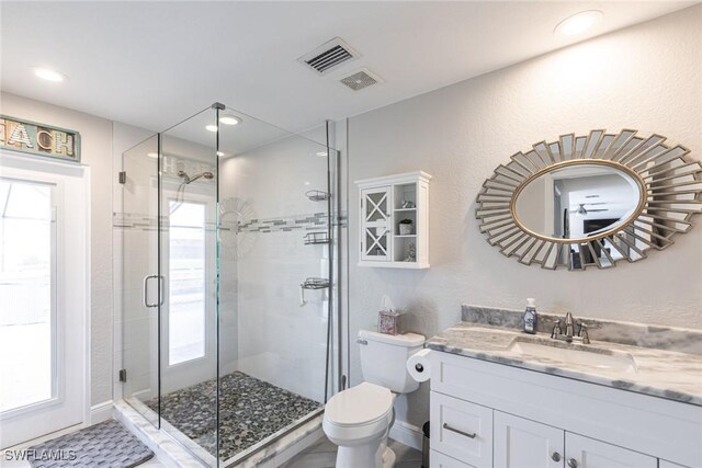 bathroom with a stall shower, visible vents, and vanity