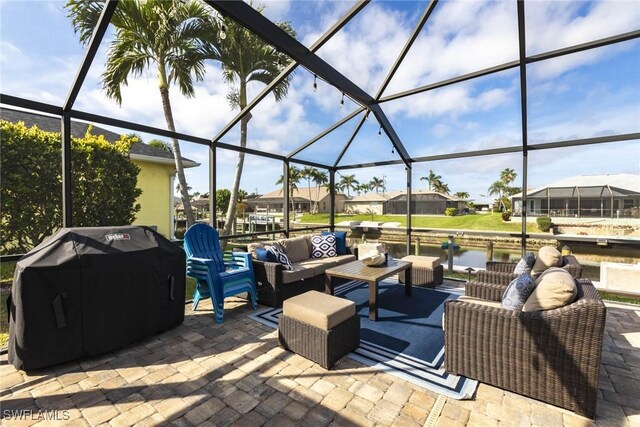 view of patio / terrace featuring a water view, glass enclosure, an outdoor living space, and area for grilling