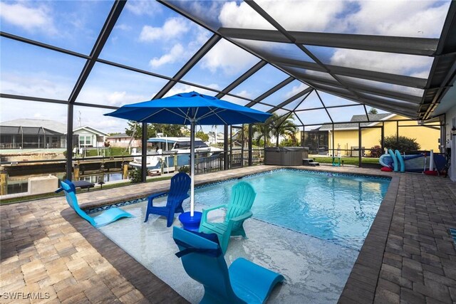 outdoor pool with glass enclosure, a patio area, and a hot tub