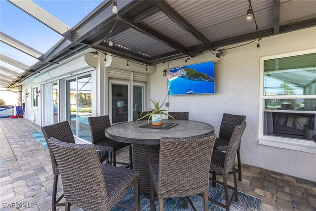 view of patio / terrace featuring outdoor dining space and a lanai