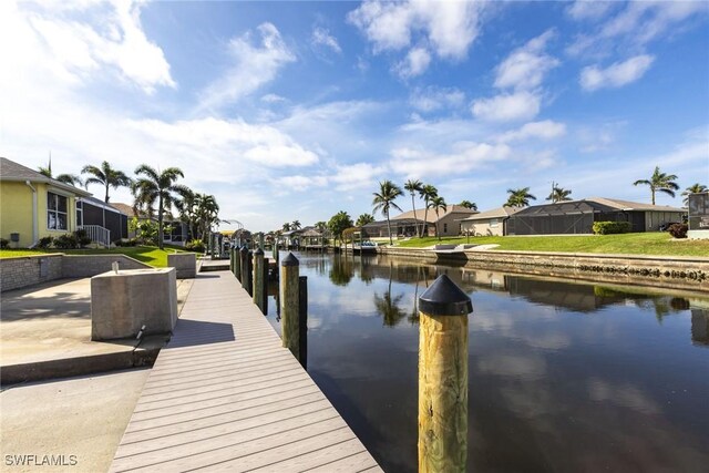 view of dock with a water view, a residential view, and a lawn