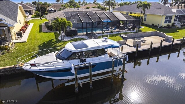 view of dock with a water view, boat lift, a residential view, and a yard