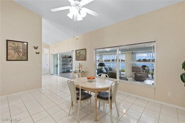 dining room featuring lofted ceiling, light tile patterned floors, baseboards, and a ceiling fan