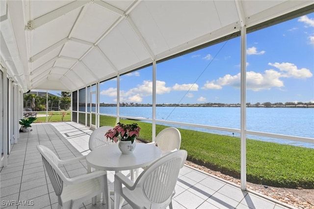 sunroom featuring a water view and lofted ceiling