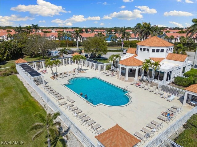 community pool featuring a residential view, fence, and a patio