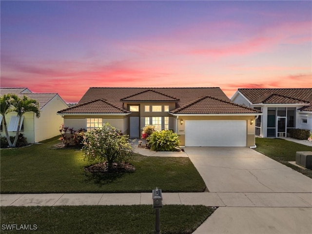 view of front of home with a garage, driveway, a front lawn, and stucco siding