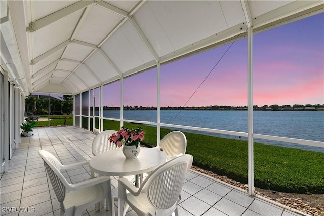 unfurnished sunroom featuring a water view and lofted ceiling