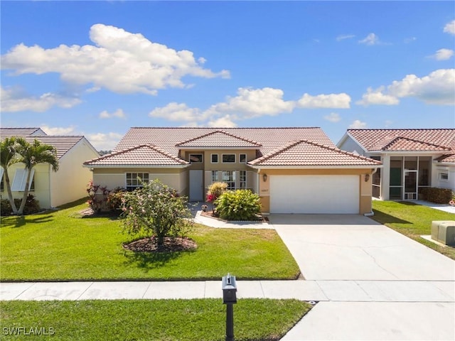 mediterranean / spanish-style house featuring an attached garage, a front lawn, concrete driveway, and stucco siding