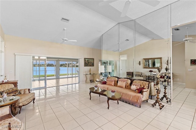 living area featuring high vaulted ceiling, visible vents, ceiling fan, and light tile patterned floors