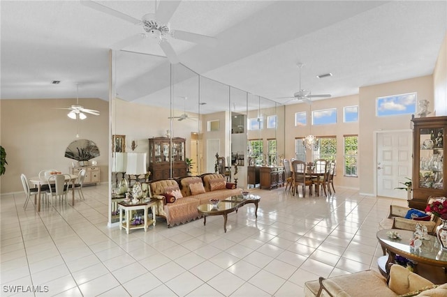 living room featuring light tile patterned floors, high vaulted ceiling, and ceiling fan with notable chandelier