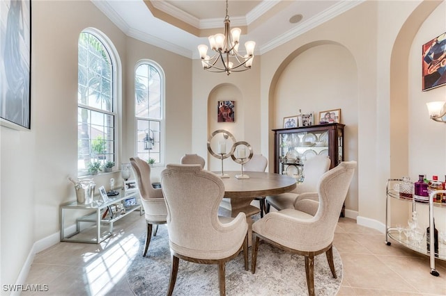 dining space featuring a chandelier, a tray ceiling, crown molding, and light tile patterned floors