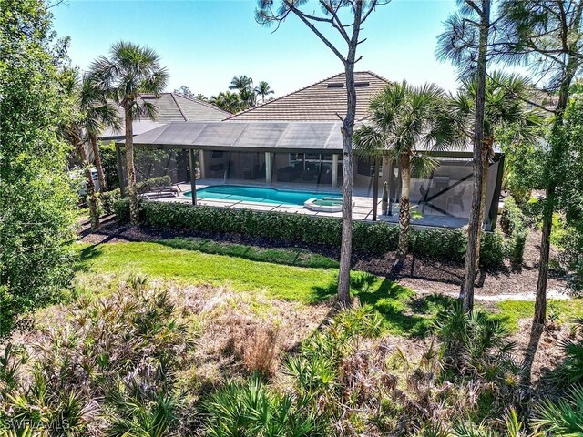 view of swimming pool with a yard, a patio area, a lanai, and a pool with connected hot tub