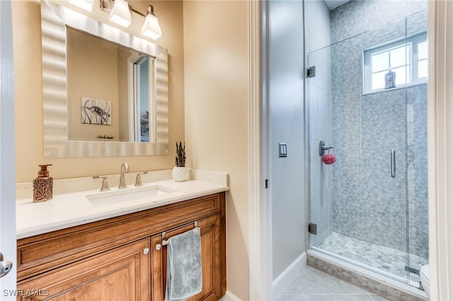 full bathroom with a stall shower, tile patterned flooring, vanity, and baseboards