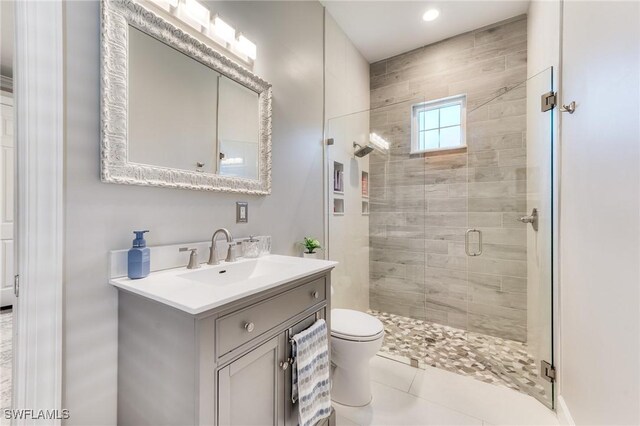 full bath featuring toilet, a stall shower, tile patterned flooring, and vanity