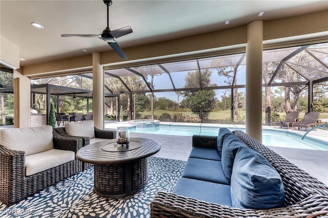 view of patio / terrace featuring a lanai, ceiling fan, a pool with connected hot tub, and an outdoor living space