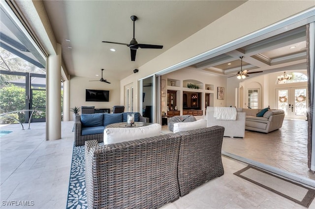 view of patio with a lanai, outdoor lounge area, a ceiling fan, and french doors