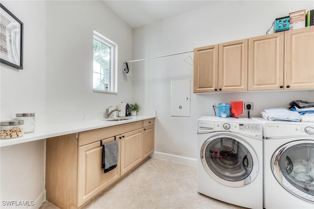 clothes washing area featuring light tile patterned flooring, a sink, baseboards, cabinet space, and washer and clothes dryer