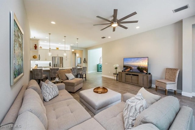 living area featuring visible vents, recessed lighting, a ceiling fan, and baseboards