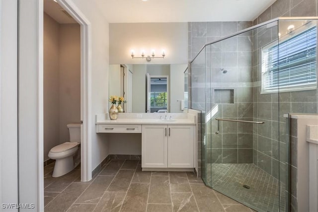 bathroom with vanity, a shower stall, and a wealth of natural light