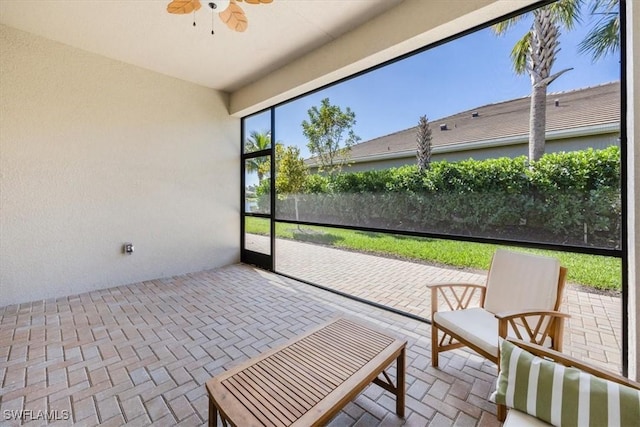 unfurnished sunroom with a ceiling fan