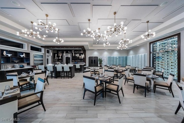 dining room with a tray ceiling, an inviting chandelier, and visible vents