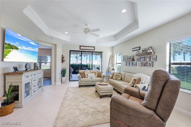 living room featuring recessed lighting, a raised ceiling, plenty of natural light, and ornamental molding