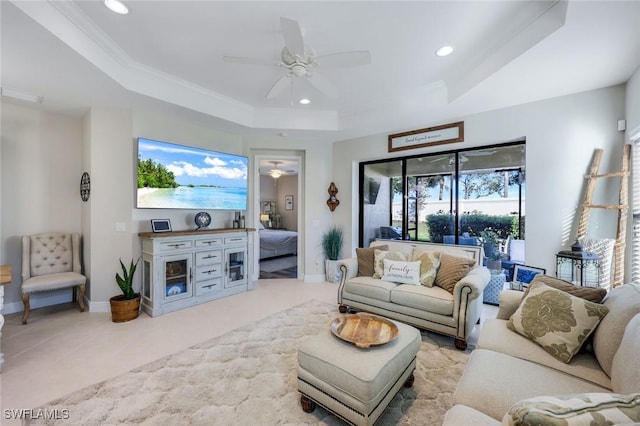 living area with a ceiling fan, a tray ceiling, recessed lighting, and baseboards