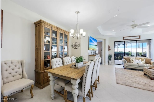 dining room featuring recessed lighting, ceiling fan with notable chandelier, and a tray ceiling