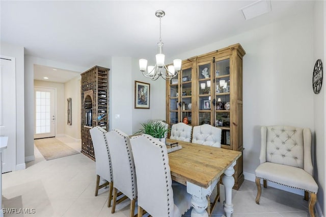 dining room with light tile patterned floors, baseboards, visible vents, and a chandelier