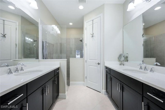 bathroom with a sink, two vanities, and walk in shower