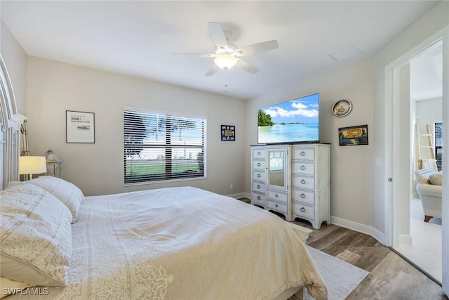 bedroom featuring ceiling fan, baseboards, and wood finished floors