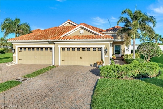 mediterranean / spanish-style home with a tiled roof, decorative driveway, an attached garage, and stucco siding