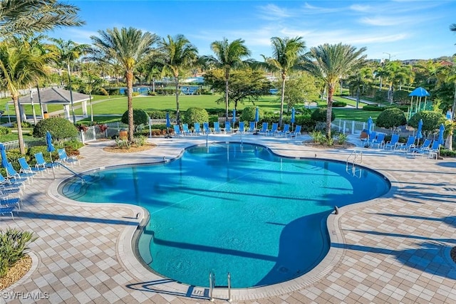 community pool with a patio and fence