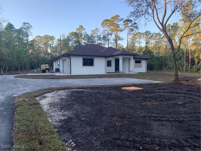 view of front of house featuring concrete driveway and stucco siding