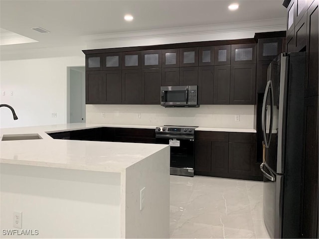 kitchen with marble finish floor, appliances with stainless steel finishes, a sink, and ornamental molding