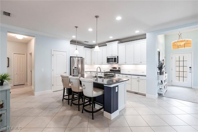 kitchen featuring light tile patterned floors, a kitchen bar, ornamental molding, and stainless steel appliances