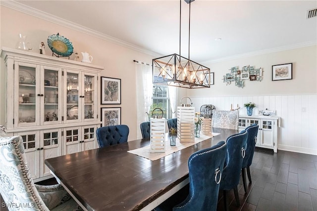 dining area featuring a notable chandelier, dark wood-type flooring, visible vents, and crown molding