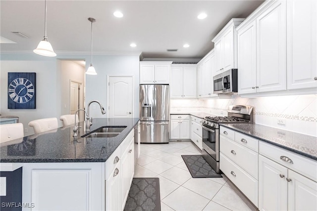 kitchen with appliances with stainless steel finishes, white cabinetry, a sink, and backsplash