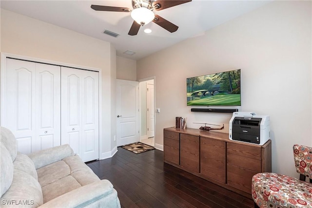 living area with baseboards, visible vents, ceiling fan, and dark wood-type flooring