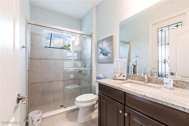 full bath with toilet, a stall shower, tile patterned floors, and vanity