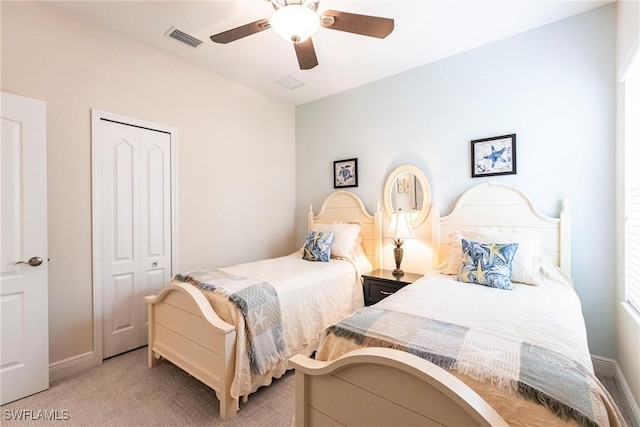 bedroom with a closet, visible vents, a ceiling fan, light carpet, and baseboards