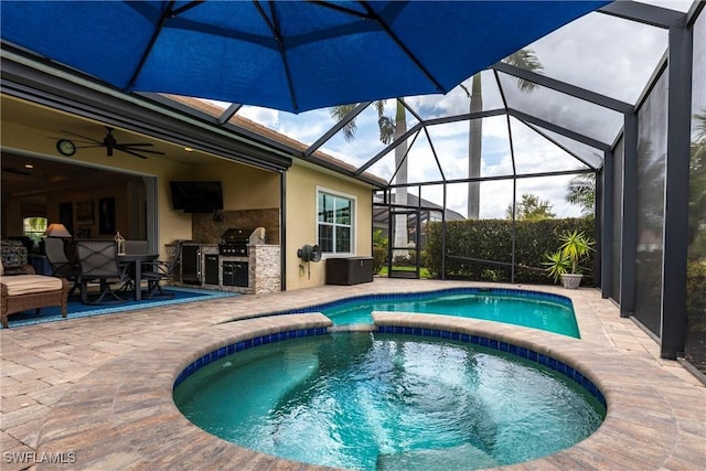 view of swimming pool featuring an outdoor kitchen, a ceiling fan, a patio, a lanai, and a pool with connected hot tub