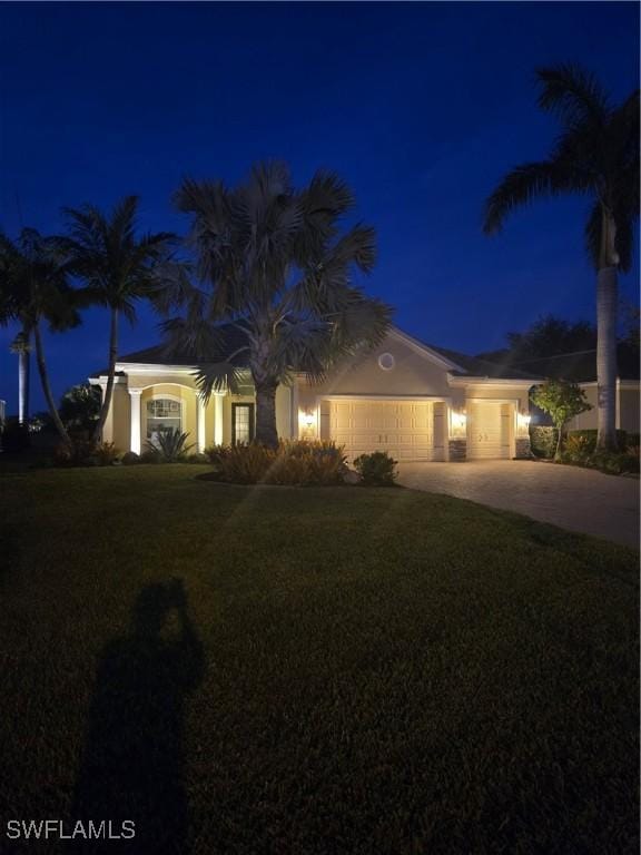 view of front facade with driveway, a lawn, and an attached garage