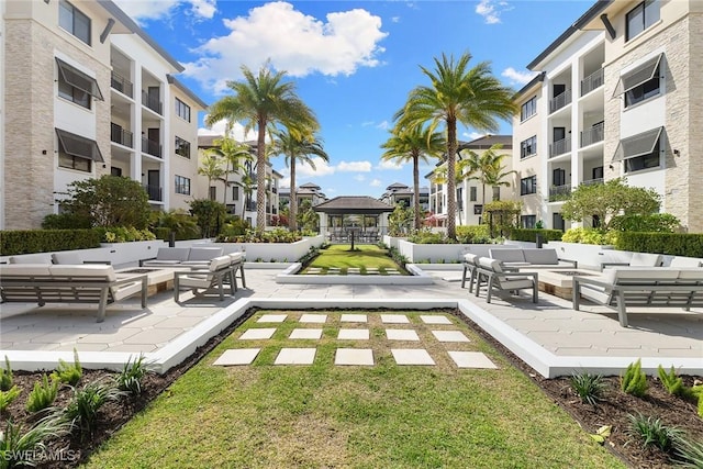 view of home's community featuring an outdoor living space, a lawn, and a patio area